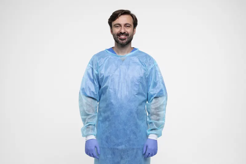 Profesional con bata desechable y guantes de protección