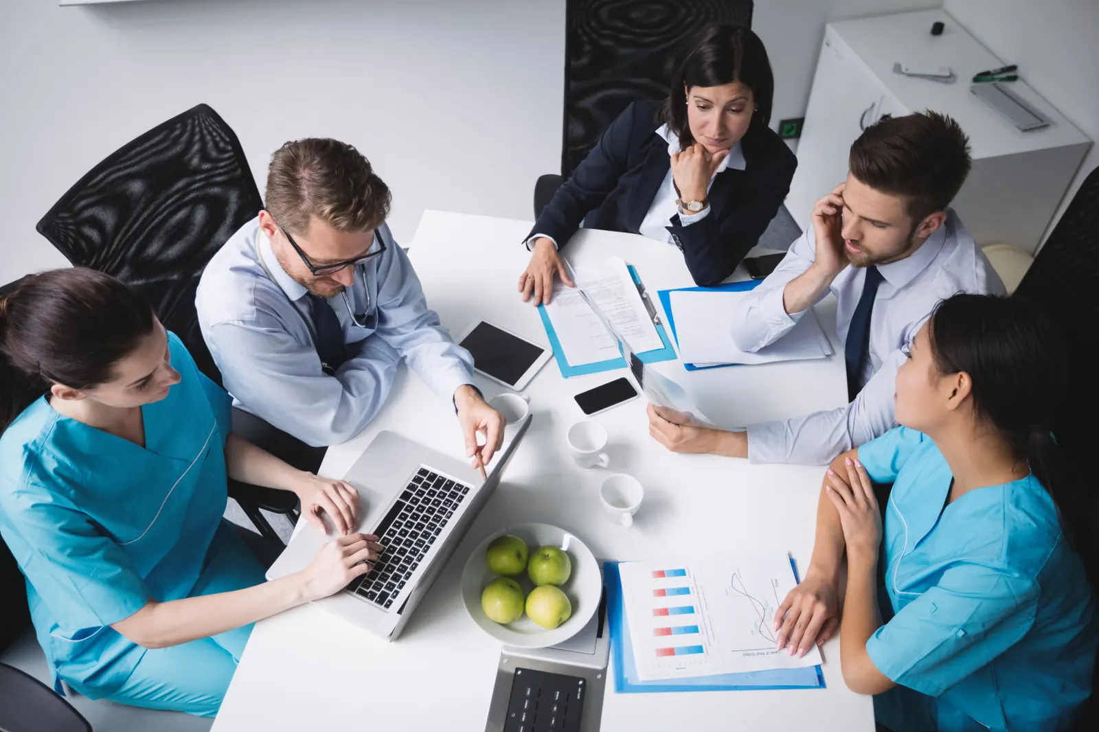Equipo de profesionales de la salud reunido revisando informes