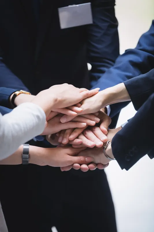 Manos de un equipo unidas en señal de alianza